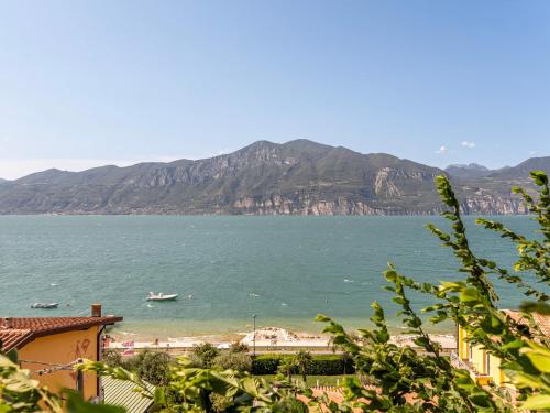 a view of a beach with a boat in the water at GuestHost - Lake Garda Lovely Flat with Pool in Assenza di Brenzone