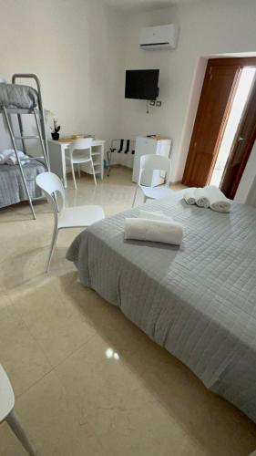 a bedroom with a bed and chairs and a table at La Spiga in Gangi