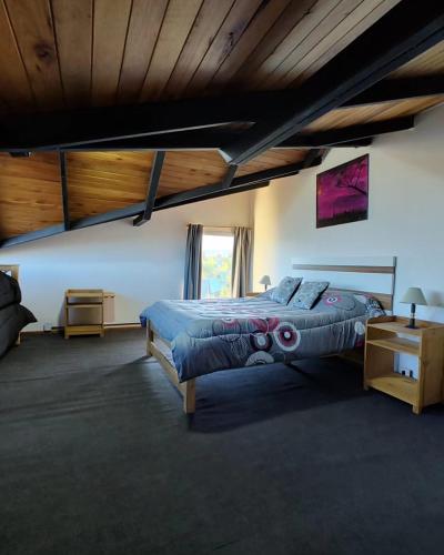 a bedroom with a large bed and a window at Sol de montaña, Bariloche. in San Carlos de Bariloche