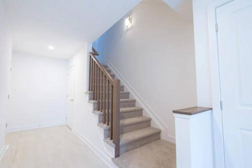 a staircase in a home with white walls at 2 Bedroom Modern Home & Close to Airport Downtown in Ottawa