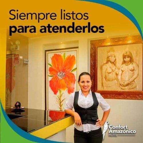 a woman standing in a room with a sign at Hotel Confort Amazónico in Iquitos