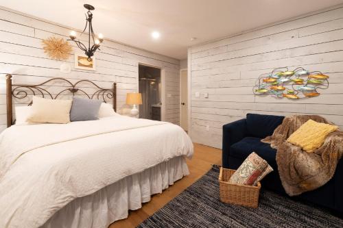 a bedroom with a large bed and a blue chair at Sunfish Suite in Peggy's Cove