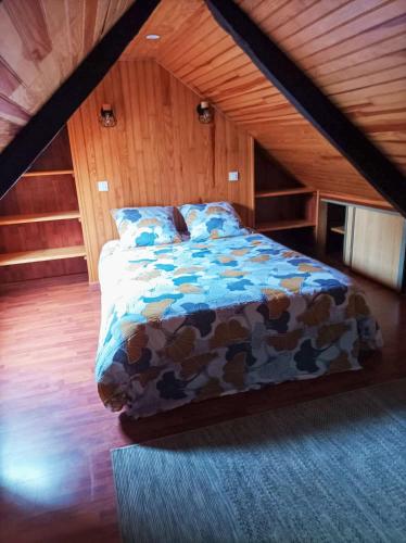une chambre avec un lit dans un grenier dans l'établissement La pierre du bois, à Kergloff