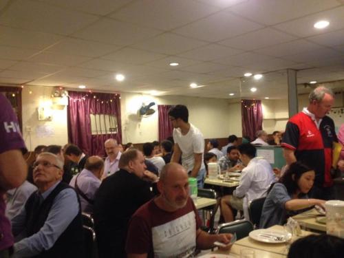 a group of people sitting at tables in a room at New Euro Asia Guest House in Hong Kong