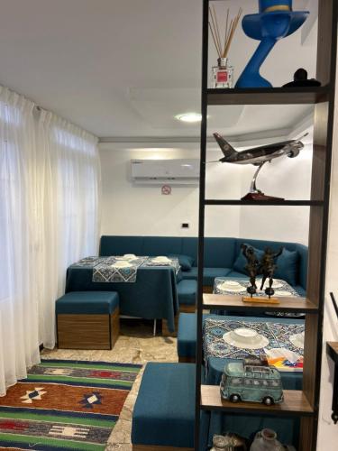 a living room with a blue couch and a shelf at Celestia Boutique Inn - Boutique Stay Overlooking Jerash Ruins in Jerash