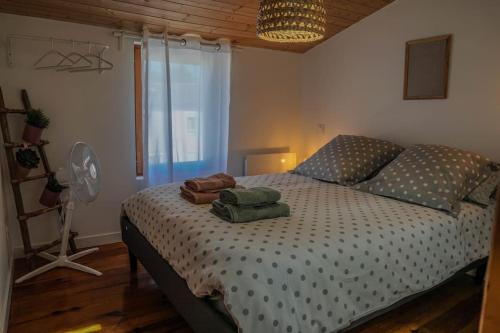 une chambre avec un lit avec un ventilateur et une fenêtre dans l'établissement Maison en plein coeur Mirepoix, à Mirepoix