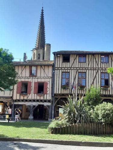 un vieux bâtiment avec une flèche dans une cour dans l'établissement Maison en plein coeur Mirepoix, à Mirepoix