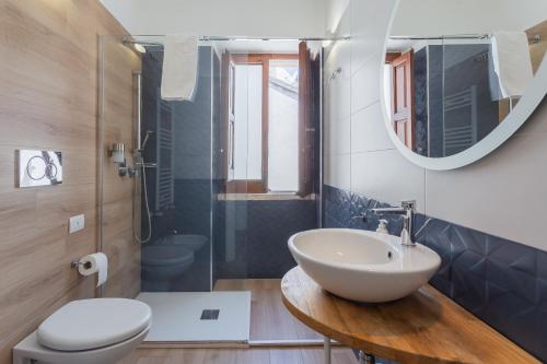 a bathroom with a sink and a toilet and a mirror at Santaló B&B in Bitonto