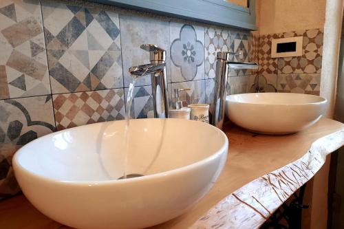 a bathroom with two white sinks on a counter at Casa Pinocchio appartamento esperienziale in San Giorgio Canavese