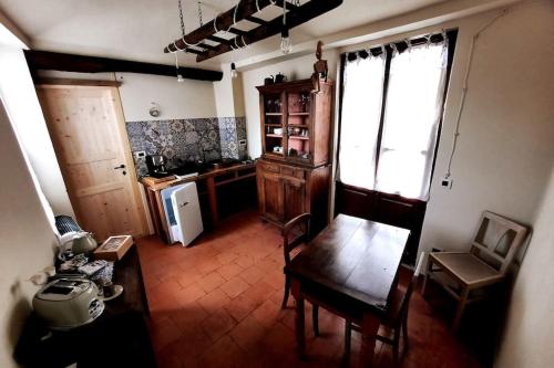 a living room with a table and a kitchen at Casa Pinocchio appartamento esperienziale in San Giorgio Canavese