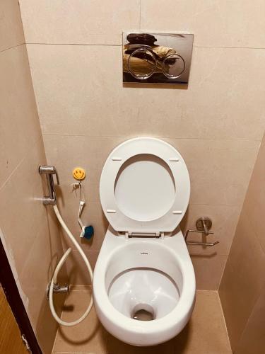 a bathroom with a white toilet with a shower at Royal orbit studio in Ghaziabad