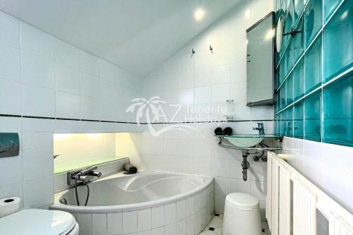 a bathroom with a tub and a toilet and a sink at Fabulous beach house in Las Americas in Playa de las Americas