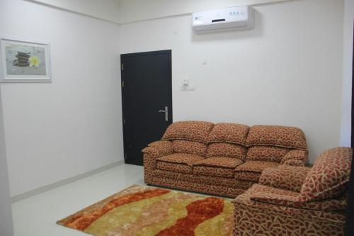 a living room with a couch and a chair at Maan Hotel Apartment in Ḩilf