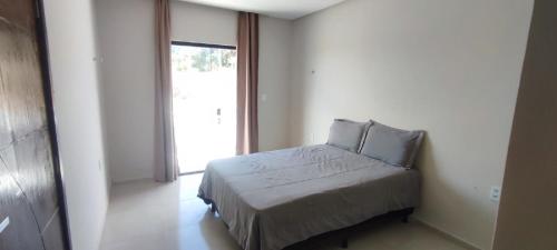 una camera da letto con un letto e una grande finestra di Casa Brisas do Caldas! a Cruz