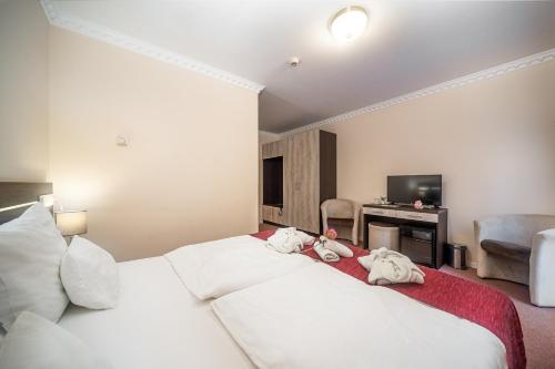a hotel room with two beds with stuffed animals on them at Termál Hotel Vesta in Tápiószecső