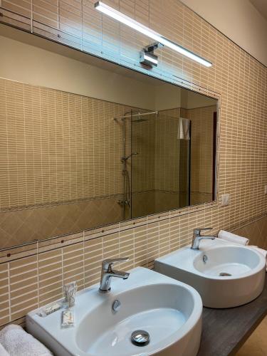 a bathroom with two sinks and a large mirror at Beb dragonara in Torremaggiore