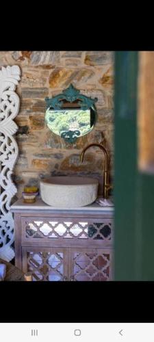 a bathroom with a sink and a stone wall at Almond Blossom Cottage 2 in Philotium