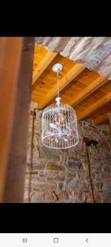 a bird cage hanging from the ceiling of a building at Almond Blossom Cottage 2 in Philotium