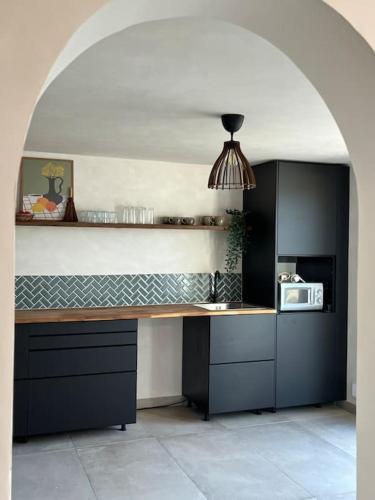 - une cuisine avec un comptoir et un four micro-ondes dans l'établissement Appartement RDC en Bas de Villa avec Chambre, à Le Val