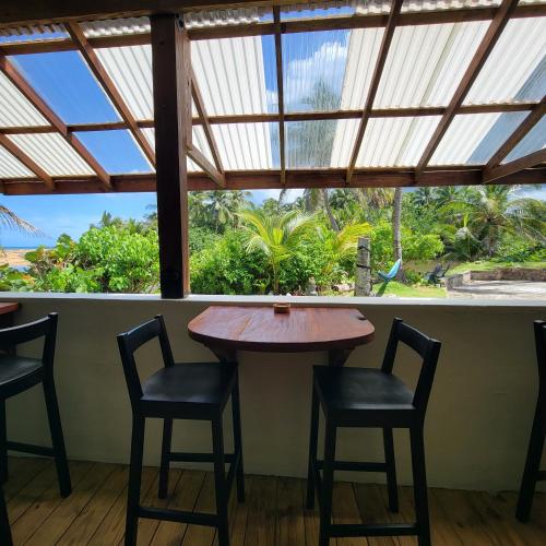 a table and chairs in a room with a window at Casa Coral in Luquillo