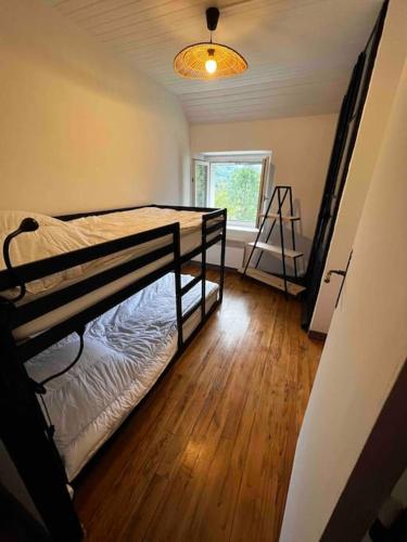 une chambre avec deux lits superposés et une fenêtre dans l'établissement Gîte la petite maison, à Soulan
