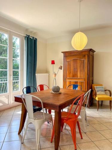 une salle à manger avec une table et des chaises en bois dans l'établissement Maison Cosy avec Jardin et Cheminée sur Vichy, à Creuzier-le-Vieux