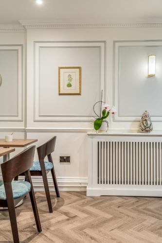 a dining room with a table and chairs and a radiator at Princes Square in London