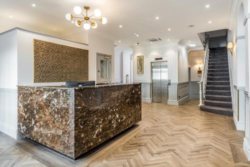 a lobby with a marble counter and stairs at Princes Square in London