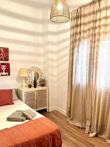 a bedroom with a bed and a window with a mirror at Apartamento con Parking El Rincón del Arte Granada Centro in Granada