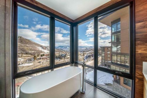 a bath tub in a room with large windows at One Snowmass West 603 by Snowmass Mountain Lodging in Snowmass