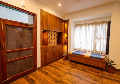 a room with a bed and a window and a door at Vista Valley Stay, Luxury 3 BHK Villa Kangra, Dharamshala in Dharamshala