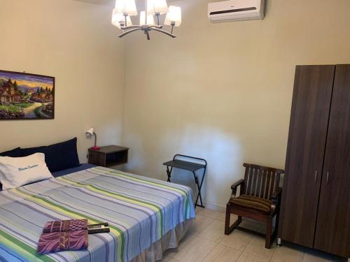 a bedroom with a bed and a chair and a cabinet at Olas del mar in La Libertad