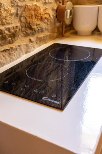 a kitchen counter with a black counter top at Almond Blossom Cottage 2 in Philotium