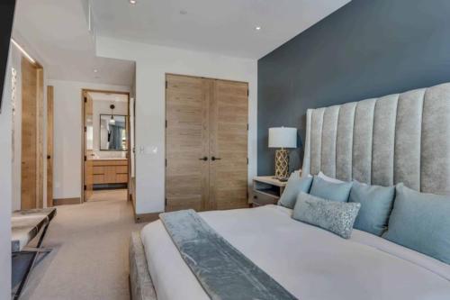 a bedroom with a large white bed with blue pillows at One Snowmass West 303 by Snowmass Mountain Lodging in Snowmass