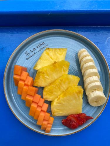 a plate of food with pineapple and carrots and a banana at Casa García Rent Home in Guatapé