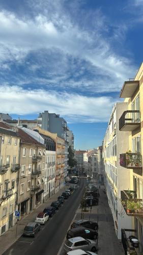 a city street with parked cars and buildings at Garden Campo de Ourique Guest House - Hostel in Lisbon
