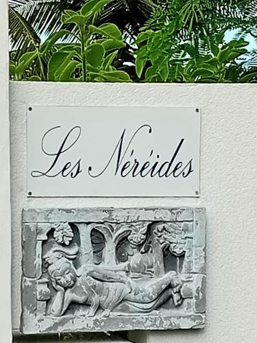a sign that says les meriodes and a statue at Villa Les Nereides in Le Moule