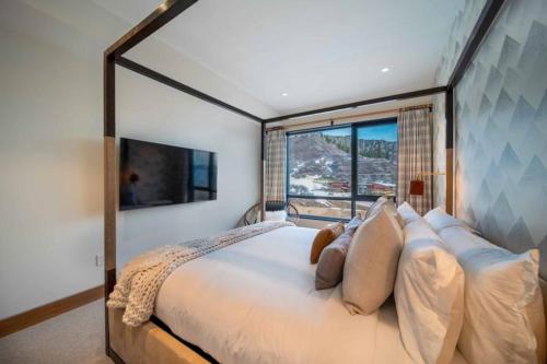 a bedroom with a large bed with a large window at One Snowmass West 501 by Snowmass Mountain Lodging in Snowmass