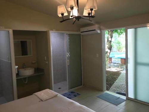 a bedroom with a bed and a bathroom with a sink at Olas del mar in La Libertad