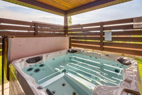 a hot tub on a deck with a fence at Stylish Montana Vacation Rental with Private Hot Tub in Red Lodge