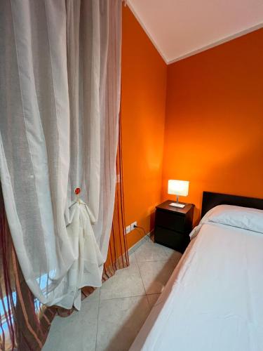 a bedroom with orange walls and a bed and a window at Beb dragonara in Torremaggiore