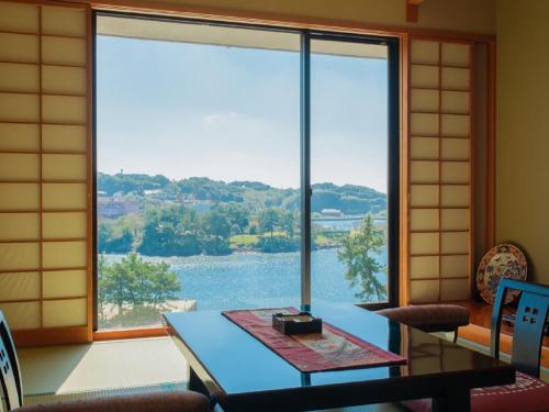 a room with a table and a large window at View Hotel Iki in Iki