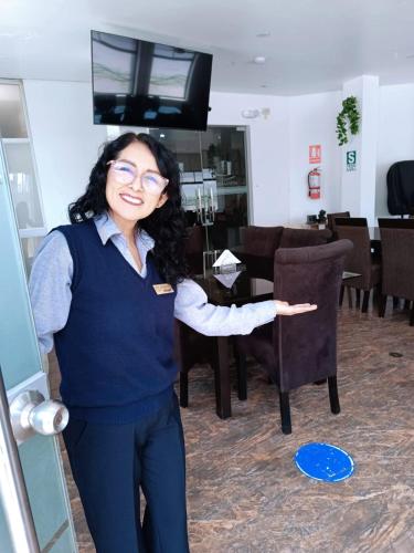 a woman standing in a room with her hand out at Hotel San Martín in San Juan de Marcona