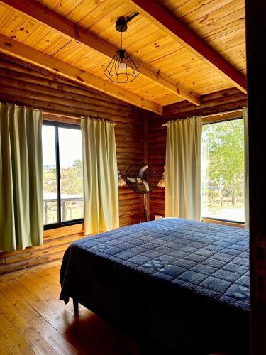 a bedroom with a bed in a room with windows at Villa Nicolasa in Villa Yacanto