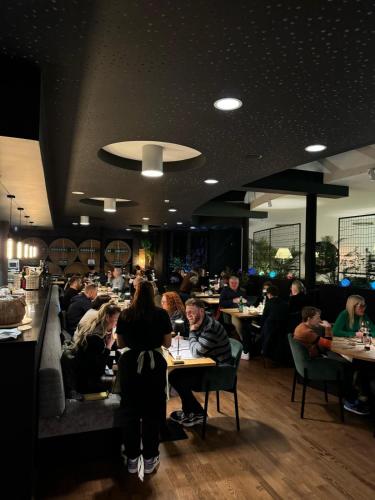 a group of people sitting at tables in a restaurant at Hotel AL Mulino in Maasmechelen