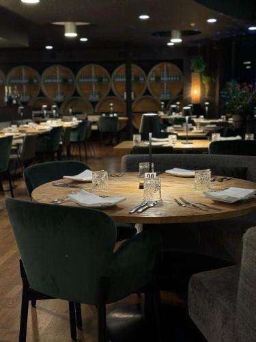 a large wooden table in a restaurant with chairs at Hotel AL Mulino in Maasmechelen