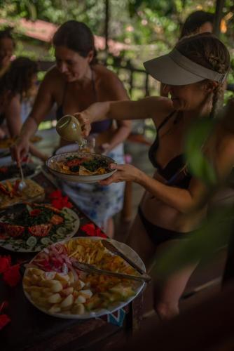 a group of people standing around a buffet of food at Dolphin Quest Jungle Lodge in Piedras Blancas