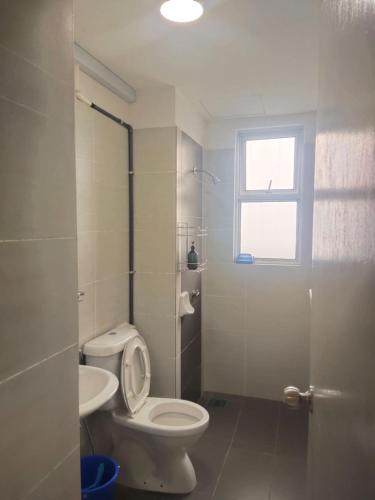 a bathroom with a toilet and a sink and a window at 1010 Homestay at MKH Avenue, Kajang Town in Kajang
