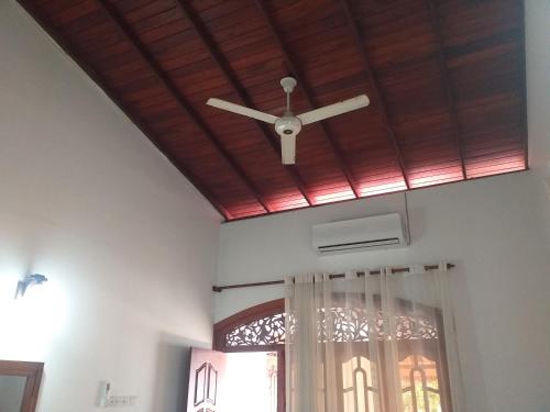 a ceiling fan in a room with a window at Sujee Villa White House in Beruwala