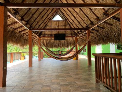 a hammock in a straw roofed pavilion with a television at KETHALYA TAYRONA Hostal in El Zaino